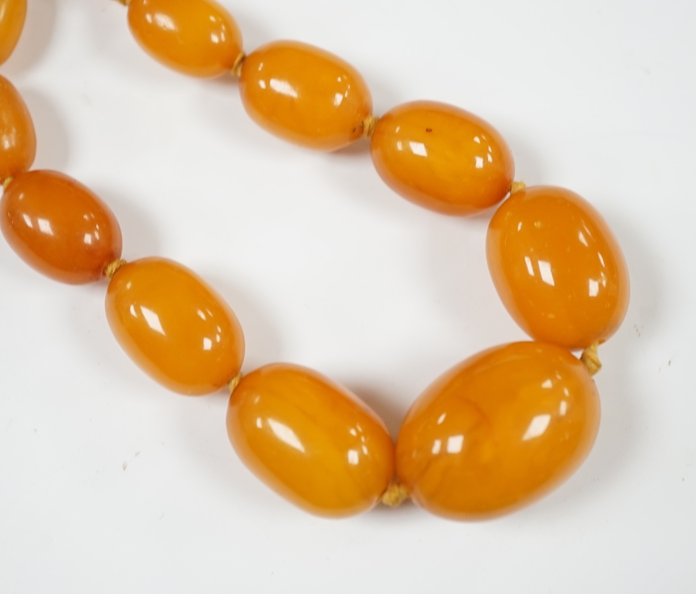 A single strand graduated oval amber bead necklace, 44cm, string broken, gross weight 39 grams. Condition - poor